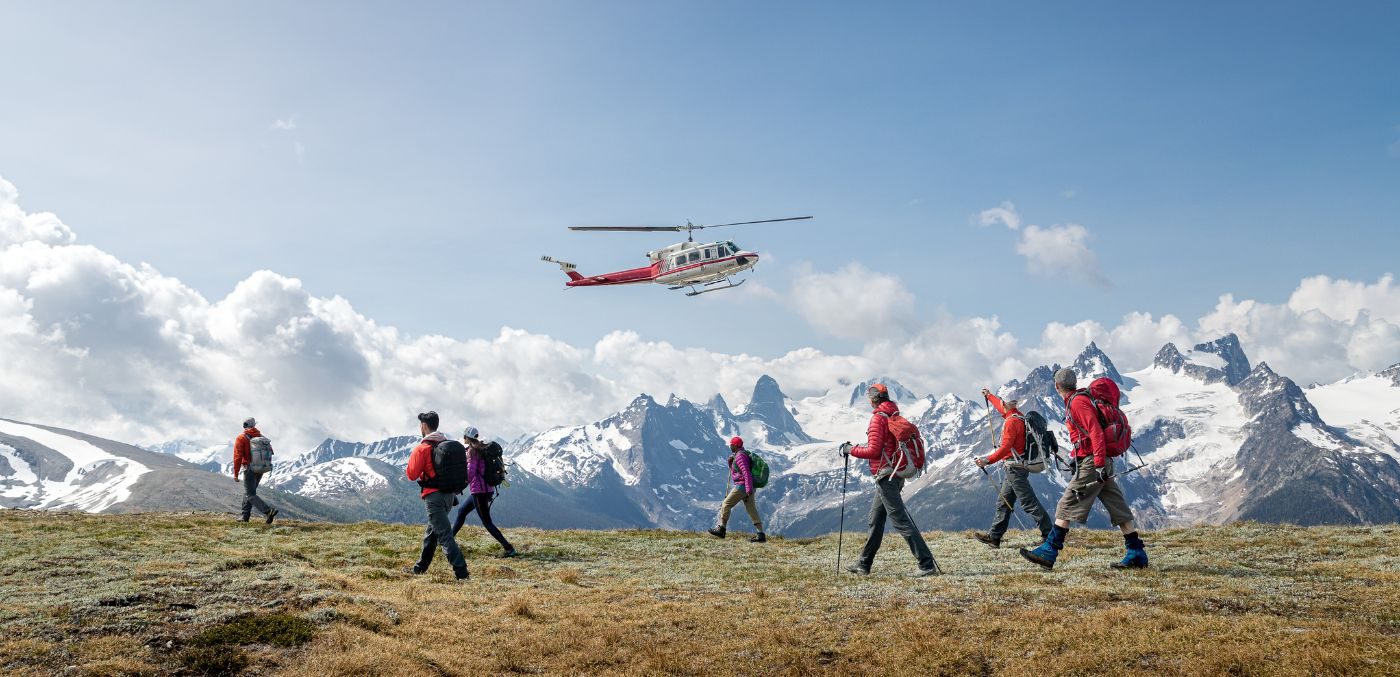 Hikers walking in mountains below helicopter