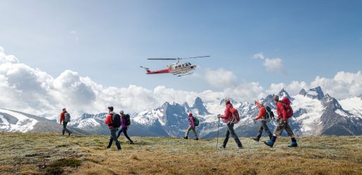 Hikers walking in mountains below helicopter
