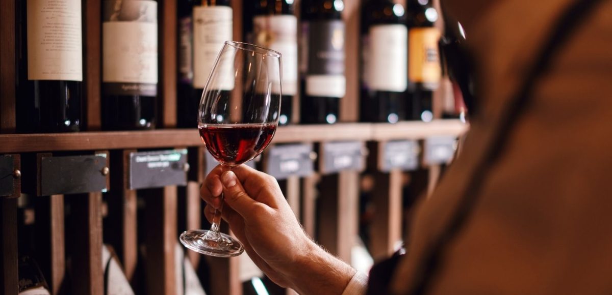 person holding a full wine glass for sampling