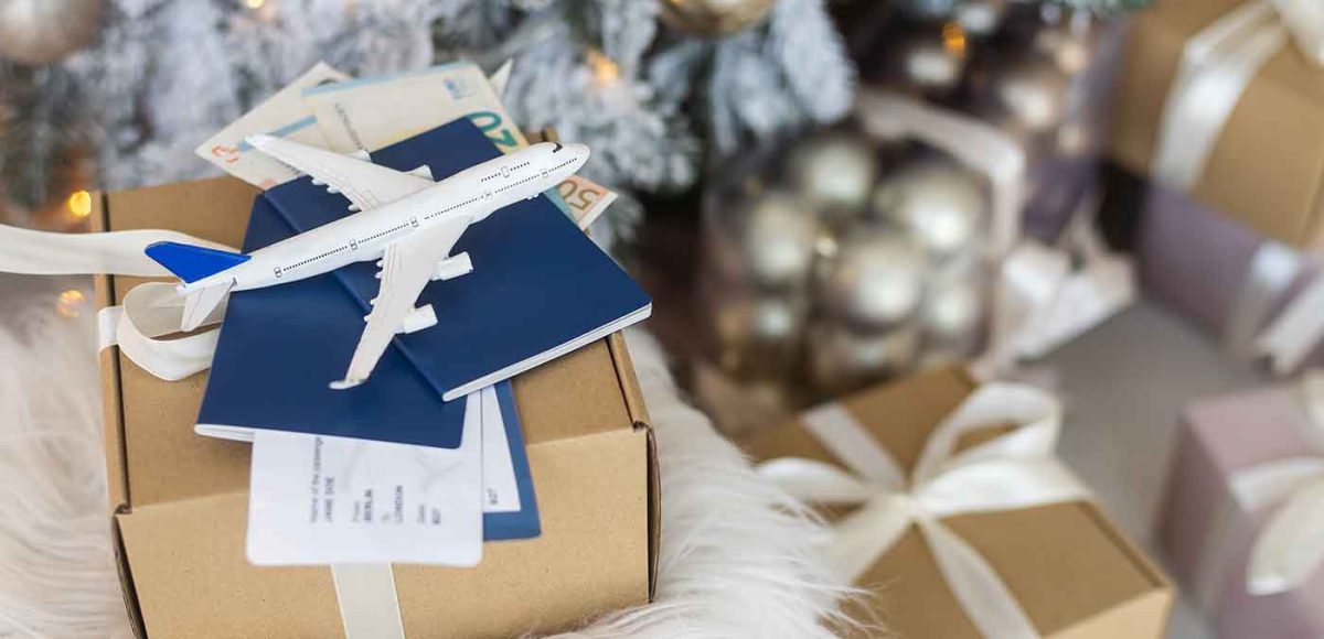 Christmas or New Year travel concept. Toy airplane with passports and gift boxes
