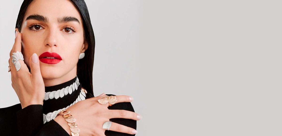 woman wearing a black top with red lipstick and fine jewellery