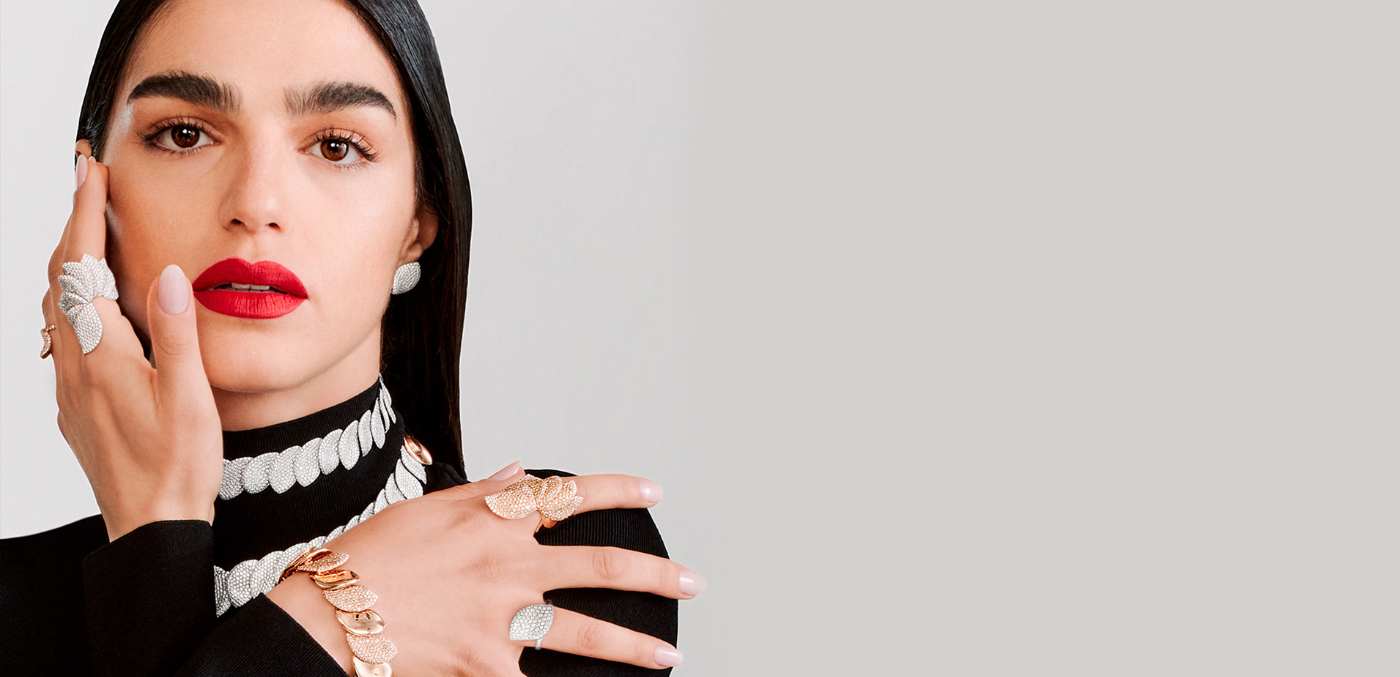 woman wearing a black top with red lipstick and fine jewellery