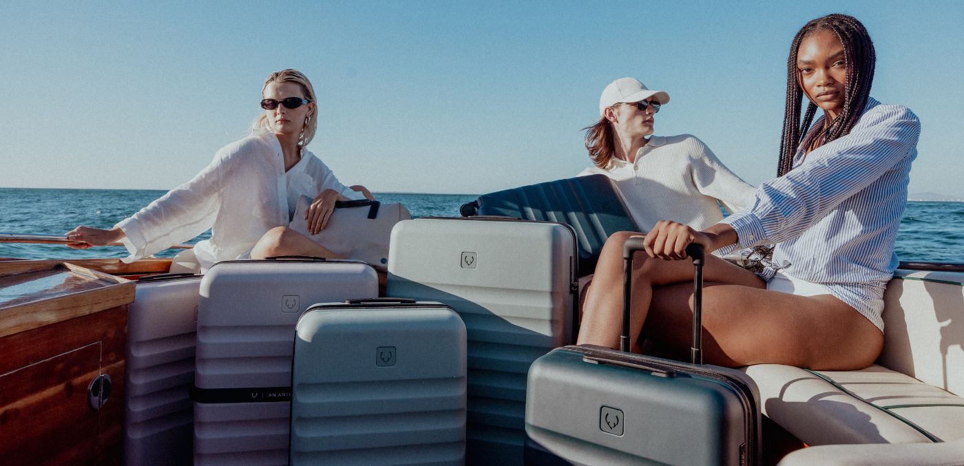 Three travellers sitting on a boat with suitcases